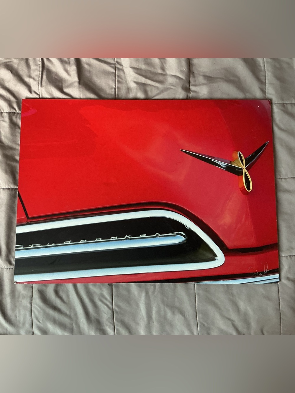 Print of a classic Studebaker grill and hood ornament mounted on a hard board.